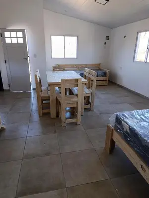 a room with a table and chairs and a bed at Sinaí Apart in Santa Rosa de Calamuchita