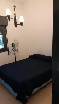 a bedroom with a black bed and a fan at Cazona Villa Carmen2 in Villa Carlos Paz
