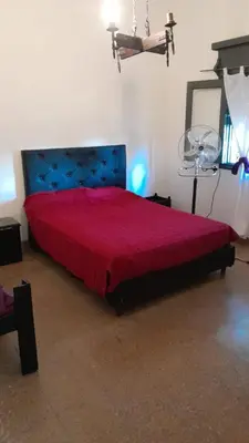 a bedroom with a large bed with a red bedspread at Cazona Villa Carmen2 in Villa Carlos Paz