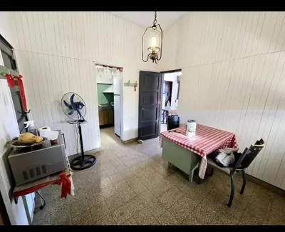 a kitchen with a table and a room with a fan at Cazona Villa Carmen2 in Villa Carlos Paz