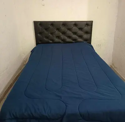 a blue bed with a black headboard in a room at La morada in Cordoba
