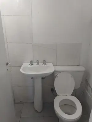 a white bathroom with a toilet and a sink at La morada in Cordoba