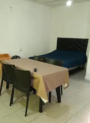 a table with chairs and a bed in a room at La morada in Cordoba