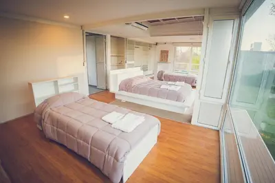 a bedroom with two beds and a large window at Lo de Paul in Hernando