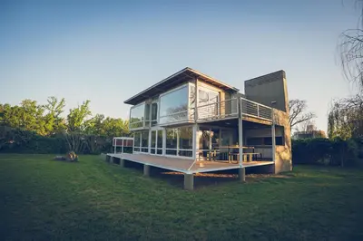 a house with a large window on a grass field at Lo de Paul in Hernando