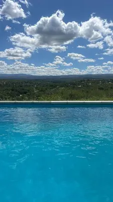 a large pool of blue water with a cloudy sky at Villa alpina in Bialet Massé