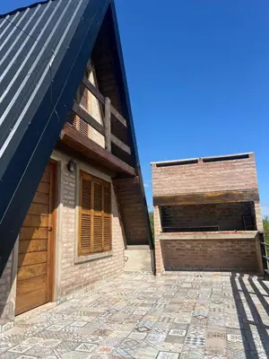 a building with a wooden door and a brick patio at Villa alpina in Bialet Massé