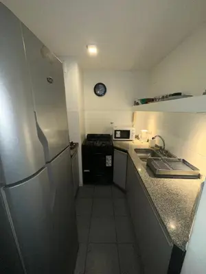 a small kitchen with a refrigerator and a stove at Departamento Nueva Córdoba in Cordoba