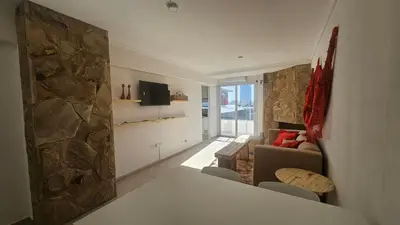 a living room with a couch and a stone wall at Magníficas VISTAS in Cordoba