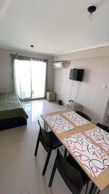 a room with a table and two chairs and a bed at Departamento Barrio Cerrado Terra 2 seguridad 24h pileta in Cordoba