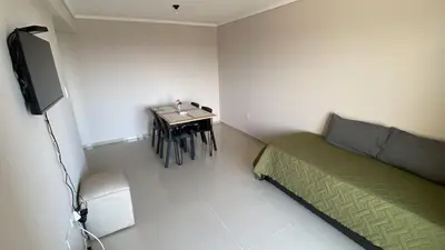 a room with a bed and a table and a television at Departamento Barrio Cerrado Terra 2 seguridad 24h pileta in Cordoba
