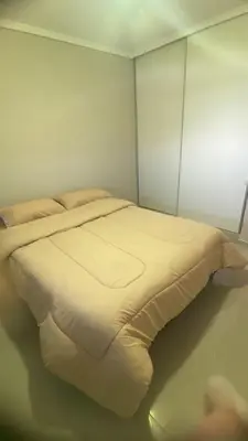 a bedroom with a bed with white sheets and pillows at Departamento Barrio Cerrado Terra 2 seguridad 24h pileta in Cordoba