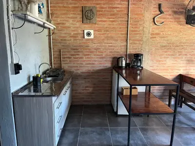 a kitchen with a counter and a table in it at Terrazas del Pinar, Loft con pileta exclusiva en bosque serrano in Villa Ciudad de America