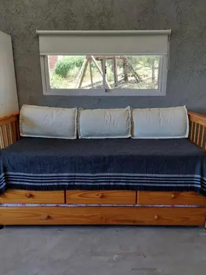 a bed in a room with a window at Terrazas del Pinar, Loft con pileta exclusiva en bosque serrano in Villa Ciudad de America