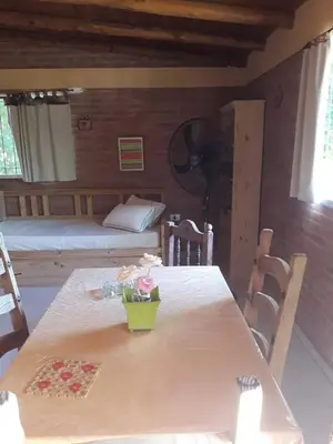 a room with a table and a bedroom with a bed at Casa Sol Y Rio in Mina Clavero