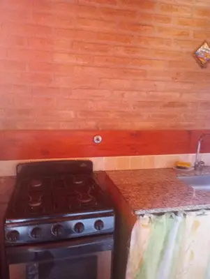 a kitchen with a stove and a sink at Casa Sol Y Rio in Mina Clavero
