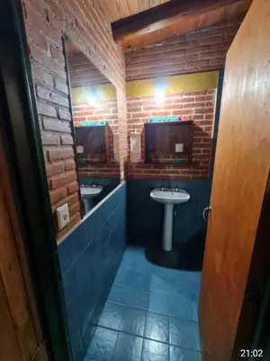 a bathroom with two sinks and two mirrors and a sink at Casa Sol Y Rio in Mina Clavero