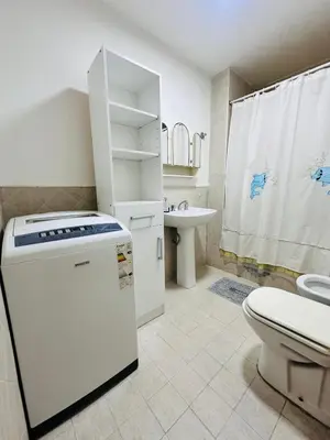 a white bathroom with a toilet and a sink at Departamento premium, ubicación céntrica, Patio Olmos! in Cordoba