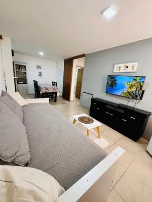 a living room with a bed and a flat screen tv at Departamento premium, ubicación céntrica, Patio Olmos! in Cordoba