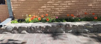 a flower garden with flowers in a stone planter at Cabaña Don Fernando in Los Hornillos
