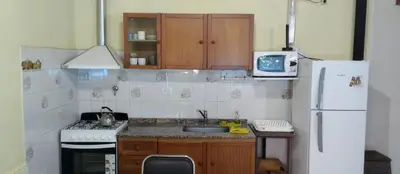 a kitchen with a sink and a white refrigerator at Cabaña Don Fernando in Los Hornillos