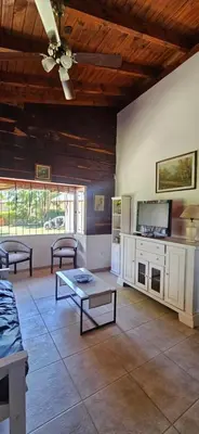 a living room with a ceiling fan and a tv at Ribera Calma in Los Reartes