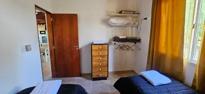 a bedroom with a bed and a dresser and a window at Ribera Calma in Los Reartes