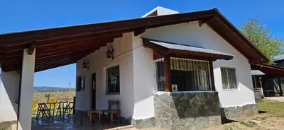 a small white house with a table and chairs at Ribera Calma in Los Reartes