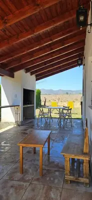 a patio with picnic tables and a fireplace at Ribera Calma in Los Reartes