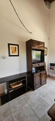 a living room with a flat screen tv in a entertainment center at Ribera Calma in Los Reartes