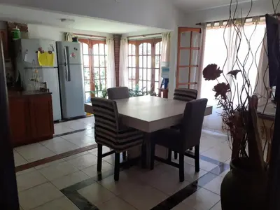 a kitchen with a table and chairs and a refrigerator at Rincon del sol in Villa Carlos Paz