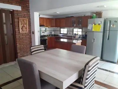 a kitchen with a table and chairs and a refrigerator at Rincon del sol in Villa Carlos Paz
