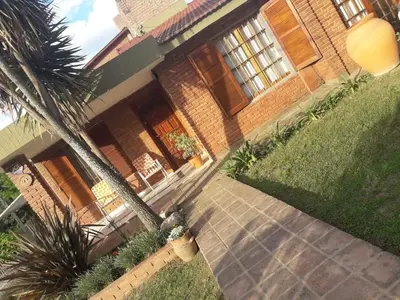 a house with a palm tree in front of it at Rincon del sol in Villa Carlos Paz