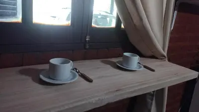 two cups and saucers sitting on a wooden table at Suite en el corazón de Nono in Nono