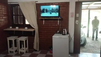 a room with a tv on a brick wall with a toilet at Suite en el corazón de Nono in Nono