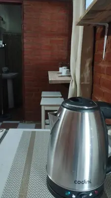a metal tea kettle sitting on a table at Suite en el corazón de Nono in Nono