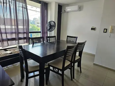 a dining room with a table and chairs and a window at Departamento Baratti's in Villa Carlos Paz
