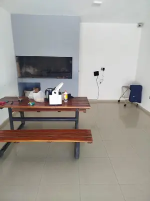 a wooden table in a room with a bench at Departamento Baratti's in Villa Carlos Paz