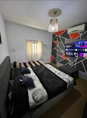 a bedroom with a large bed and a television at La casita the Aye in Villa Carlos Paz