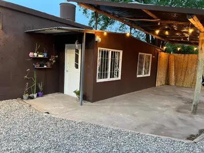 a garage with a white door and a brown wall at La casita the Aye in Villa Carlos Paz