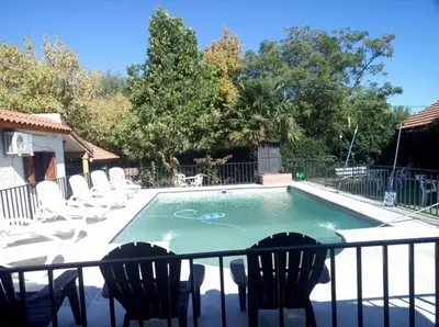 a small swimming pool with chairs and a fence at Complejo Villa del sol in Mina Clavero