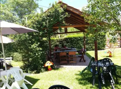 a picnic table under a wooden pergola in a yard at Complejo Villa del sol in Mina Clavero