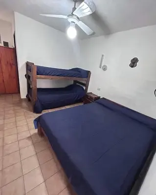 a bedroom with a blue bed and a ceiling fan at Complejo Villa del sol in Mina Clavero