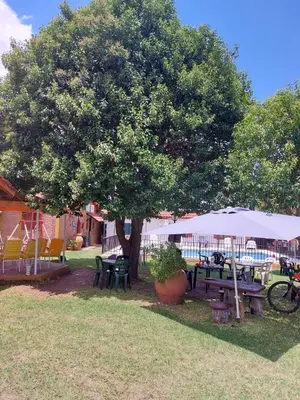 a picnic table and a tree in a yard at Complejo Villa del sol in Mina Clavero