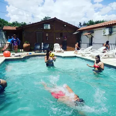 a group of people playing in a swimming pool at Complejo Villa del sol in Mina Clavero
