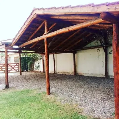 a wooden pergola on top of a yard at Complejo Villa del sol in Mina Clavero