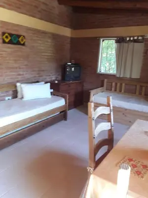 a room with two beds and a tv in it at Casa Sol Y Rio, LOFT MONOAMBIENTE in Mina Clavero