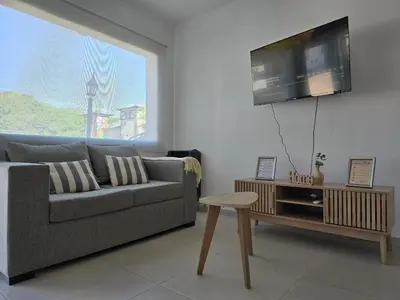 a living room with a couch and a tv on a wall at Posta Espinillos 12 in Villa General Belgrano