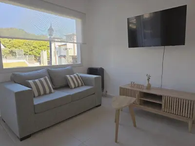 a living room with a couch and a tv at Posta Espinillos 12 in Villa General Belgrano