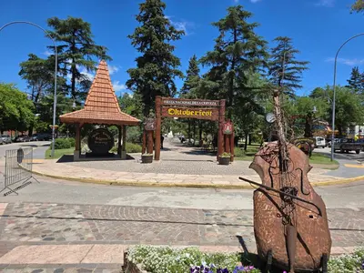 a park with a gate and a guitar statue at Posta Espinillos 12 in Villa General Belgrano